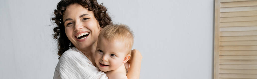 Mujer alegre abrazando a la hija bebé en casa, pancarta  - Foto, imagen
