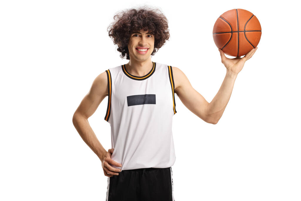 Jugador de baloncesto sosteniendo una pelota y sonriendo aislado sobre fondo blanco - Foto, Imagen
