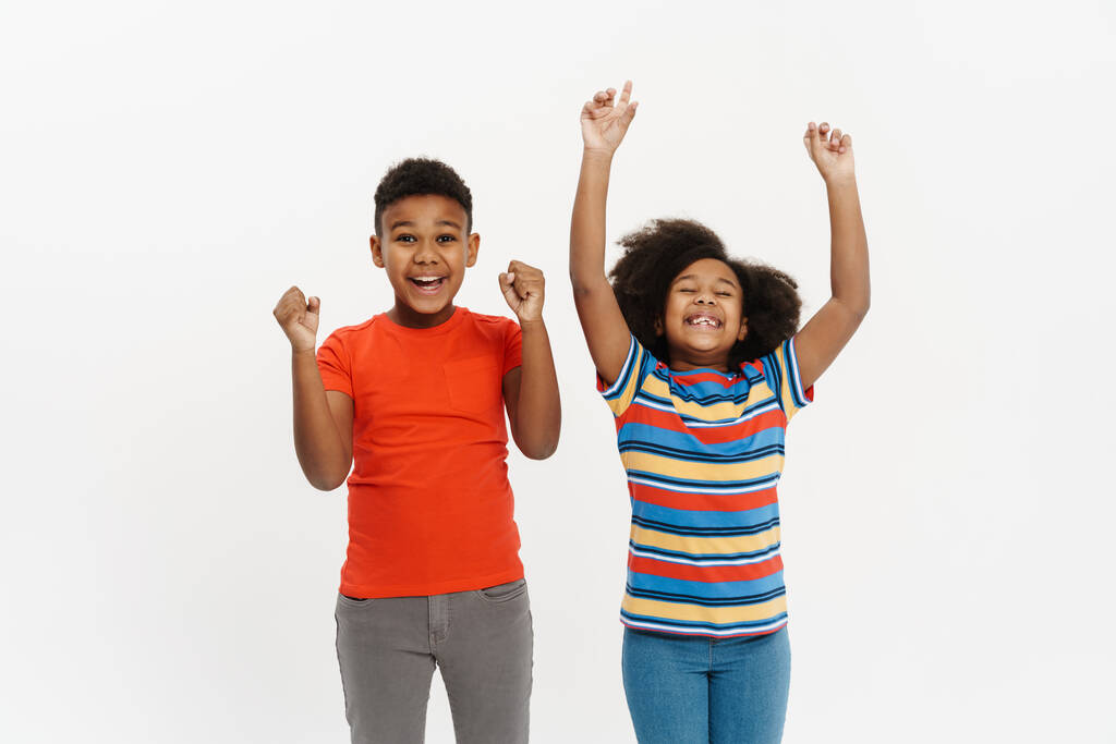 Black boy and girl laughing while making winner gesture together isolated over white background - Photo, Image