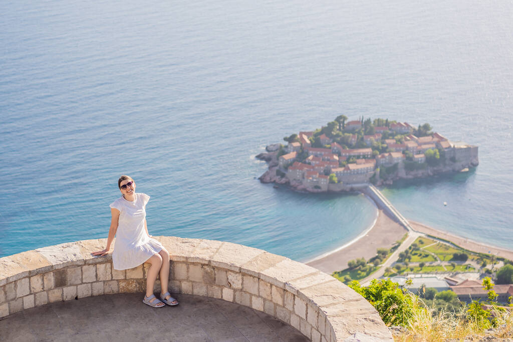 Touristin vor dem Hintergrund der schönen Aussicht auf die Insel Sveti Stefan an der Budva Riviera, Budva, Montenegro. Reisen nach Montenegro. - Foto, Bild