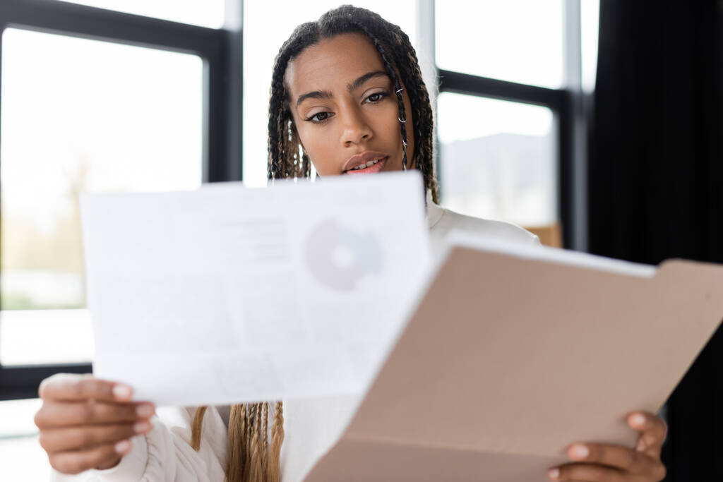 Африканская американская деловая женщина с документами и бумажной папкой в офисе  - Фото, изображение