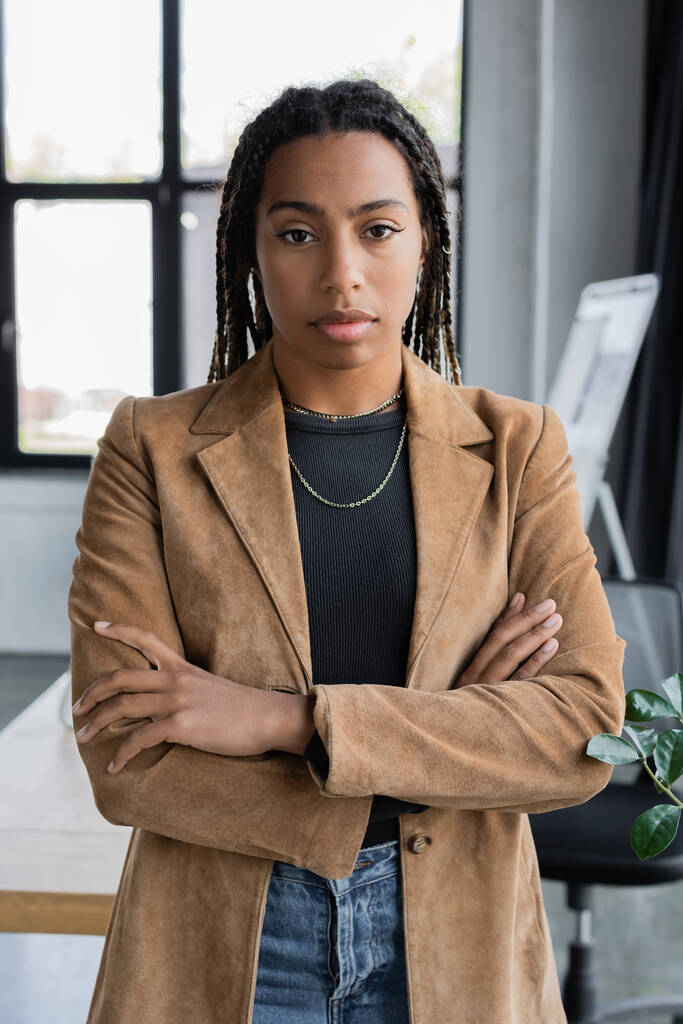 Donna d'affari afroamericana in giacca incrociando le braccia in ufficio  - Foto, immagini