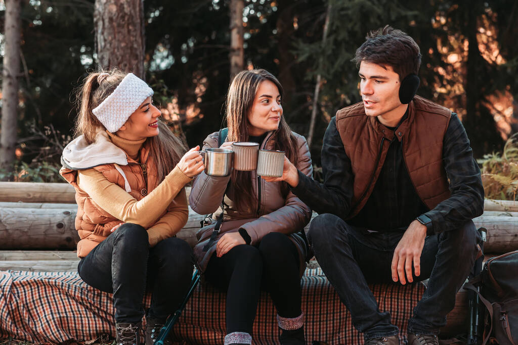金属製のお茶を飲む3人の友人、屋外のスチールカップ - 写真・画像