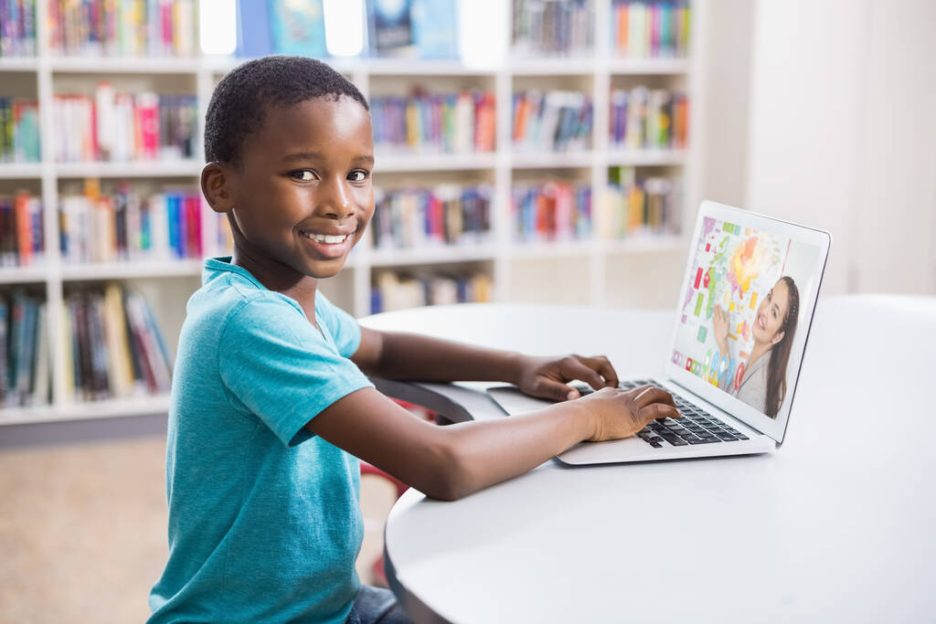 Portrait of male african american student having a video call with female teacher on laptop at library. distance learning online education concept - Photo, Image