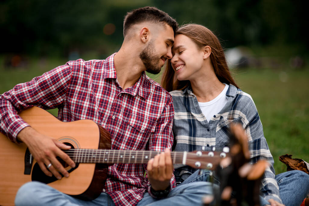 Detailní záběr zamilovaného páru na romantické rande v parku. Šťastný pár. Romantický pár s kytarou. Milostný příběh. - Fotografie, Obrázek