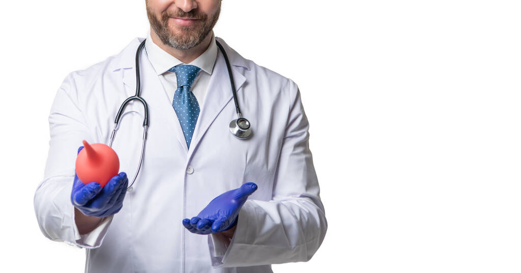 Muž lékař zobrazení obilí izolované na bílém. Doktor gastroenterolog v bílém plášti se stetoskopem drží klystýr v rukavicích, kopírovací prostor. - Fotografie, Obrázek