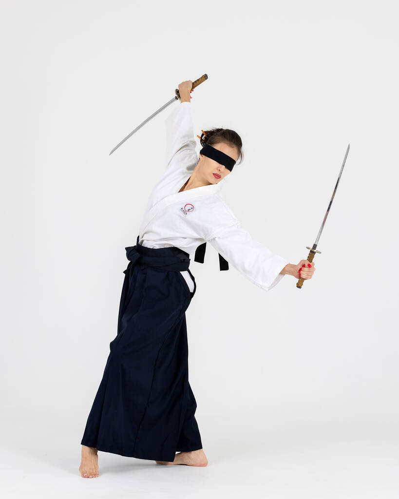 Aikido mester nő hagyományos szamuráj hakama kimono fekete öv karddal, katana fehér háttérrel. Egészséges életmód és sport koncepció. - Fotó, kép