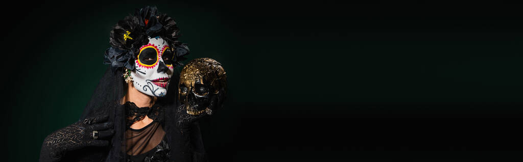 Nő Santa Muerte jelmez tartja koponya sötét zöld háttér, banner  - Fotó, kép