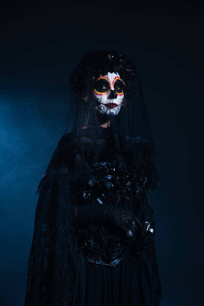 жінка в страшному макіяжі на Хеллоуїн і чорний костюм з вуаллю на темно-синьому фоні
 - Фото, зображення