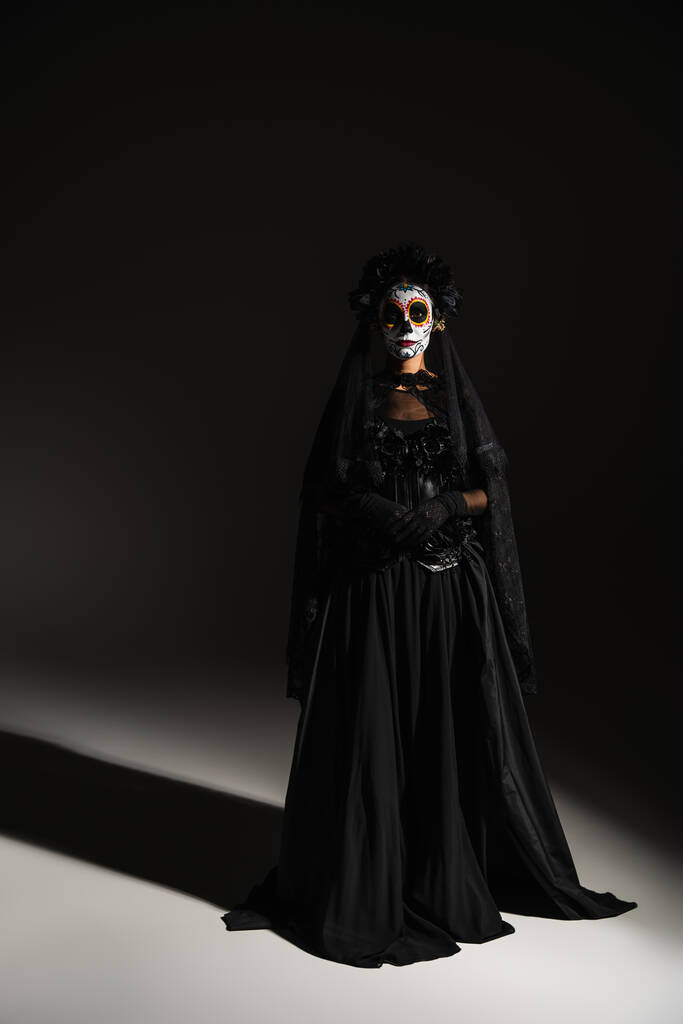 повна довжина жінки в мексиканський день мертвих костюмів і пухнастий макіяж на чорному тлі
 - Фото, зображення