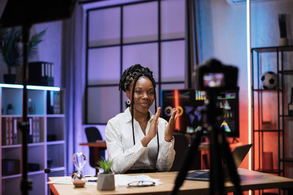 Glimlachend succesvol Afrikaans Amerikaans geschoolde zakenvrouw in formele kleding opnemen van nieuwe video voor haar internet business course en klappen handen. - Foto, afbeelding
