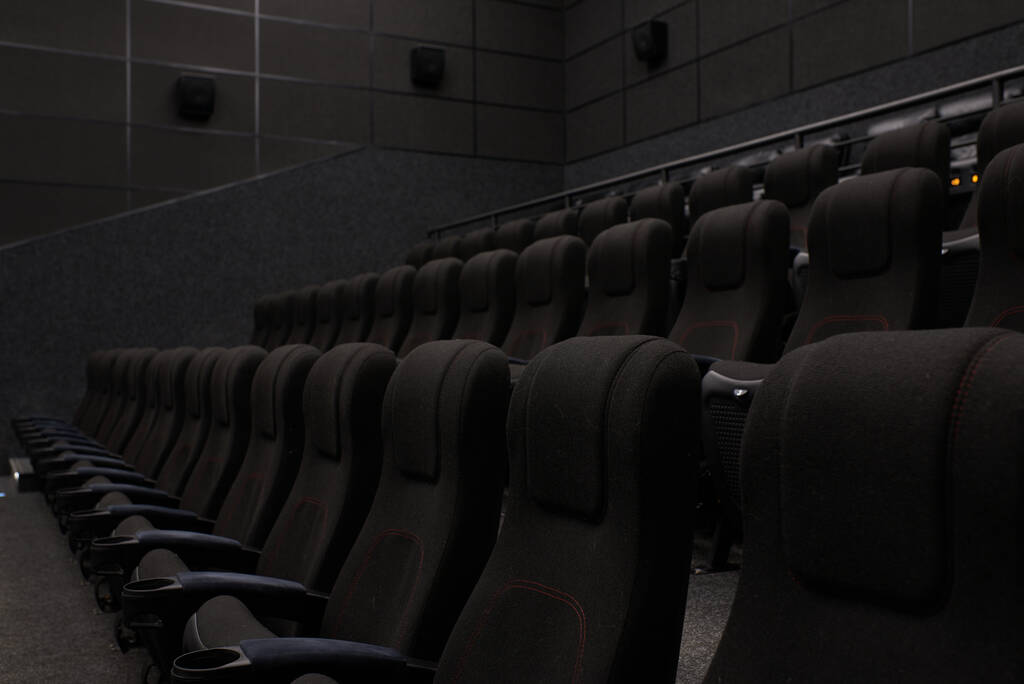 Άδεια αίθουσα κινηματογράφου με μαύρα καθίσματα και τοίχους. Κανένας κινηματογράφος - Φωτογραφία, εικόνα