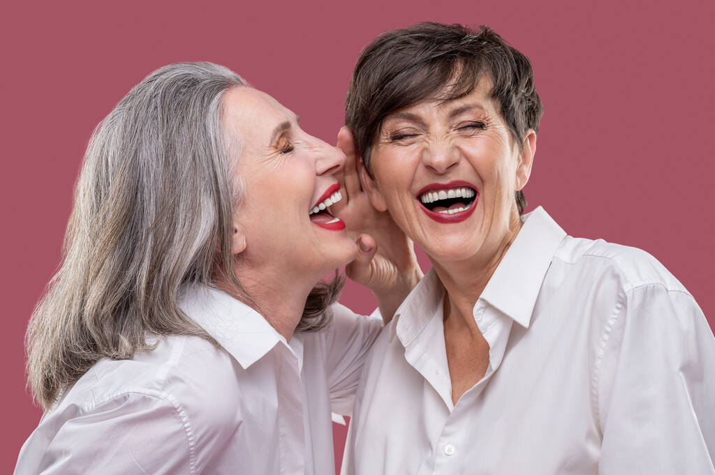 Веселюсь. Две хорошо одетые женщины, выглядящие радостными и веселыми - Фото, изображение
