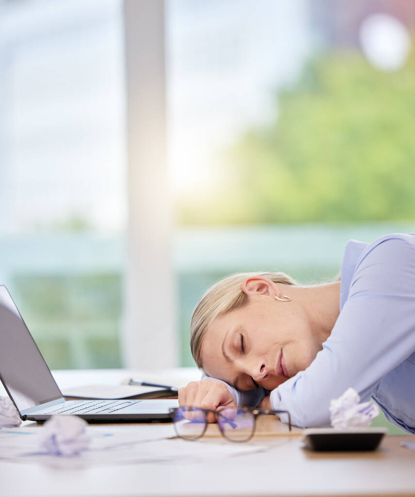 Slaap, burn-out en moe van een zakenvrouw die op haar werk aan haar bureau slaapt. Geestelijke gezondheid, overwerkt en overuren met een volwassen vrouwelijke werknemer liggend op haar bureau met haar ogen dicht. - Foto, afbeelding
