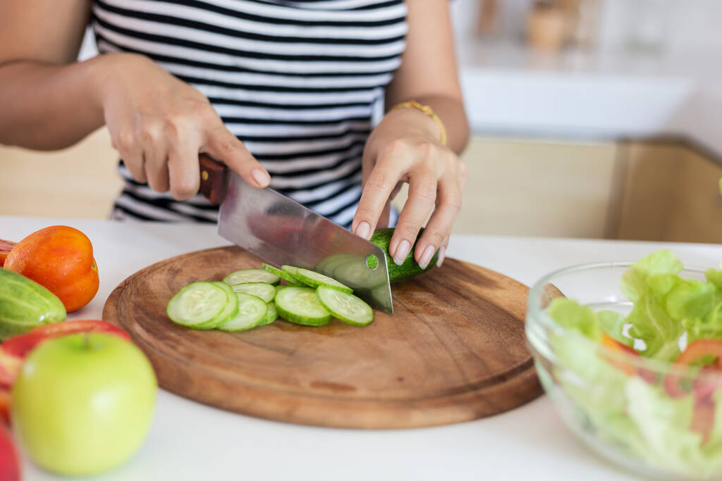 Gezond eten Aziatische vrouw kookt salade in de keuken, vrouwelijke voorbereiding van de groenten en fruit in haar huis - Foto, afbeelding