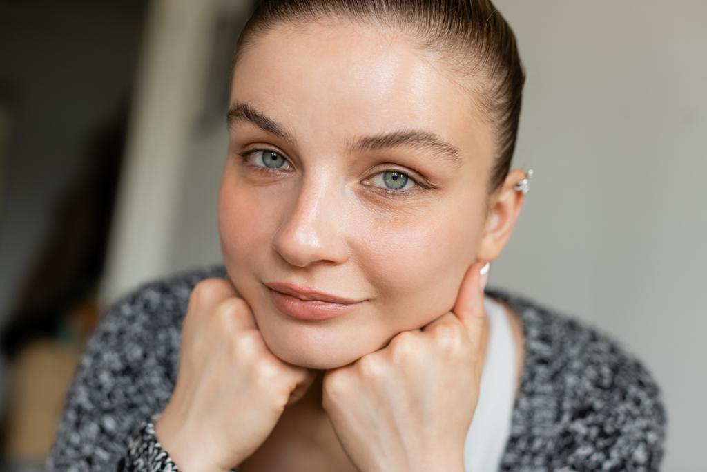 Portrét ženy v pleteném svetru při pohledu na kameru doma  - Fotografie, Obrázek