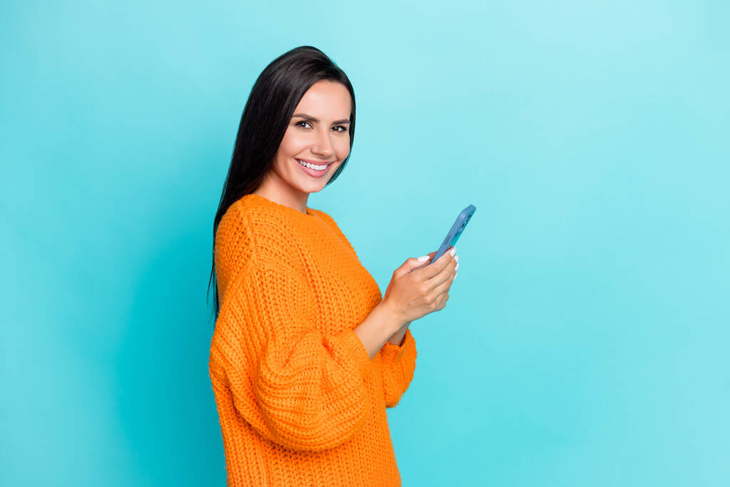 Φωτογραφία προφίλ του αρκετά χαρούμενο κορίτσι κρατήσει τηλέφωνο chatting toothy χαμόγελο απομονώνονται σε teal φόντο χρώμα. - Φωτογραφία, εικόνα