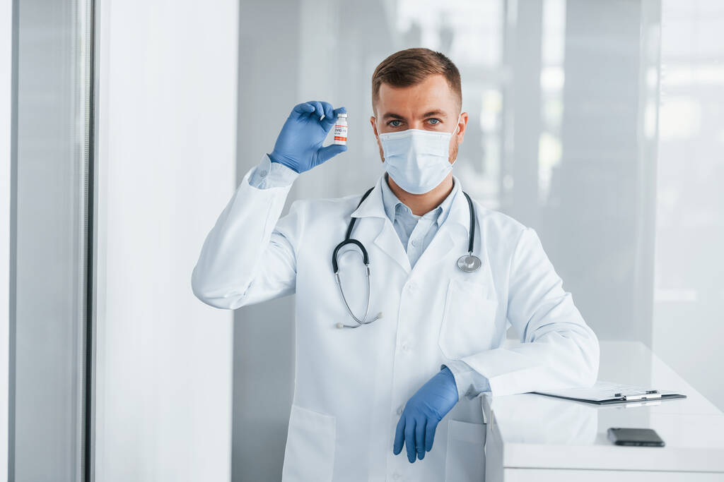 Με μπλε γάντια. Ο επαγγελματίας γιατρός με το άσπρο παλτό είναι στην κλινική.. - Φωτογραφία, εικόνα