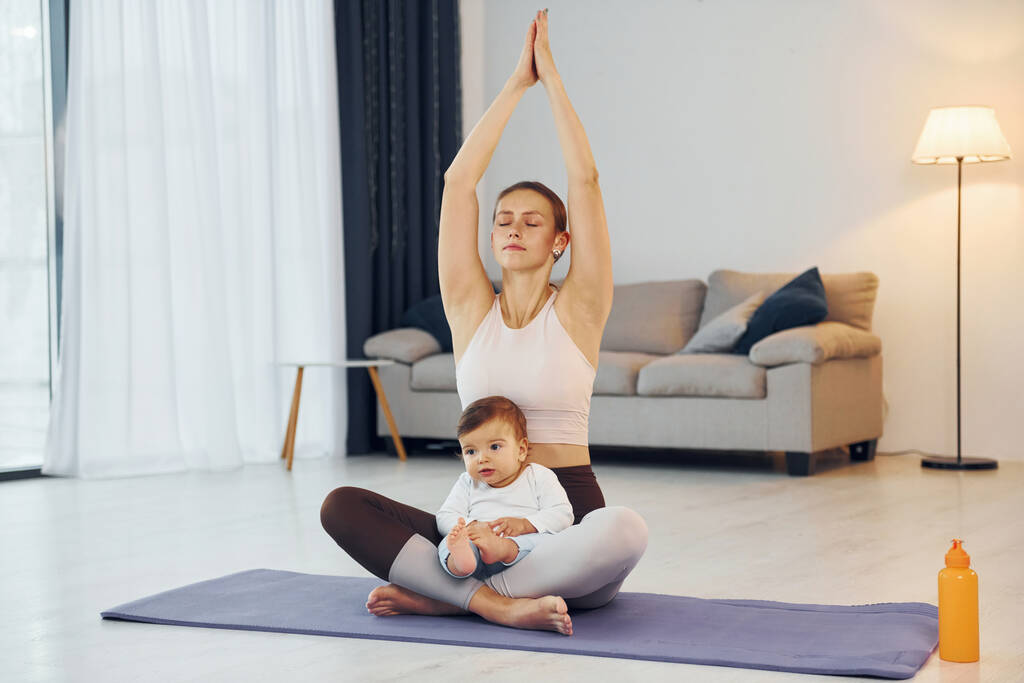 Fare esercizi di yoga. Madre con la sua figlioletta è a casa insieme. - Foto, immagini