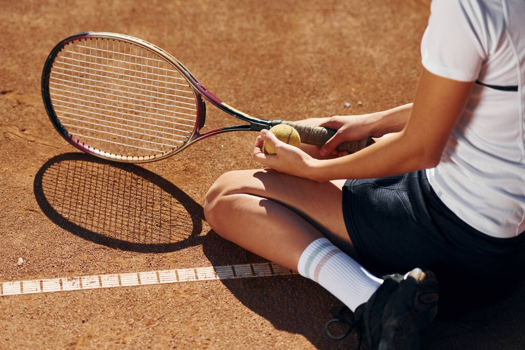На землі. Жінка-тенісистка на дворі вдень
. - Фото, зображення