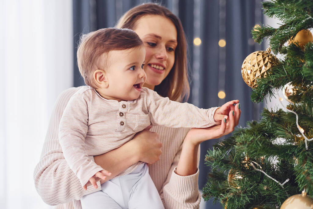 Noel ağacı süslüyorum. Anne ve küçük kızı evde birlikte.. - Fotoğraf, Görsel