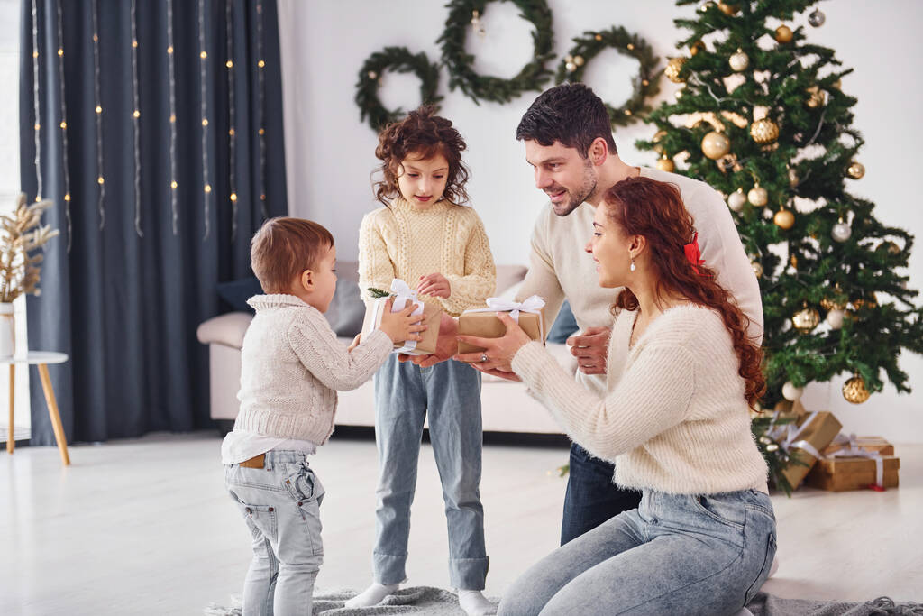 Mit Geschenkboxen. Familie feiert Neujahr mit ihren Kindern zu Hause. - Foto, Bild