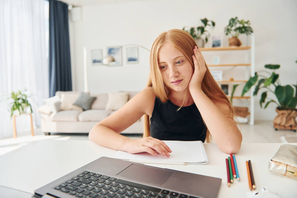 Online school. Female teenager with blonde hair is at home at daytime. - Photo, Image
