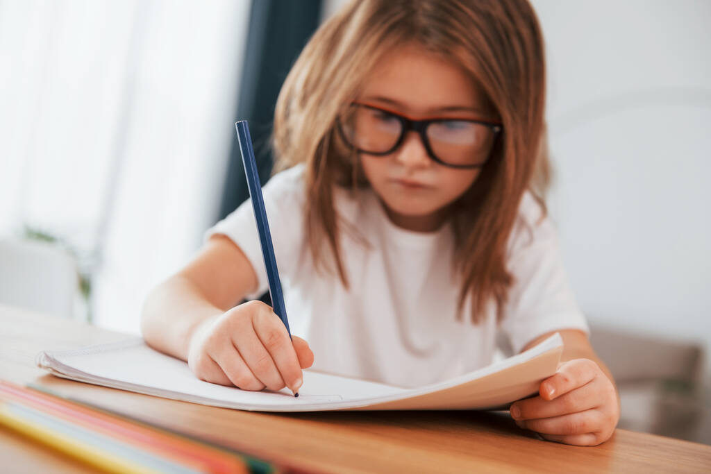 Kleines Mädchen sitzt am Tisch und lernt zeichnen. - Foto, Bild