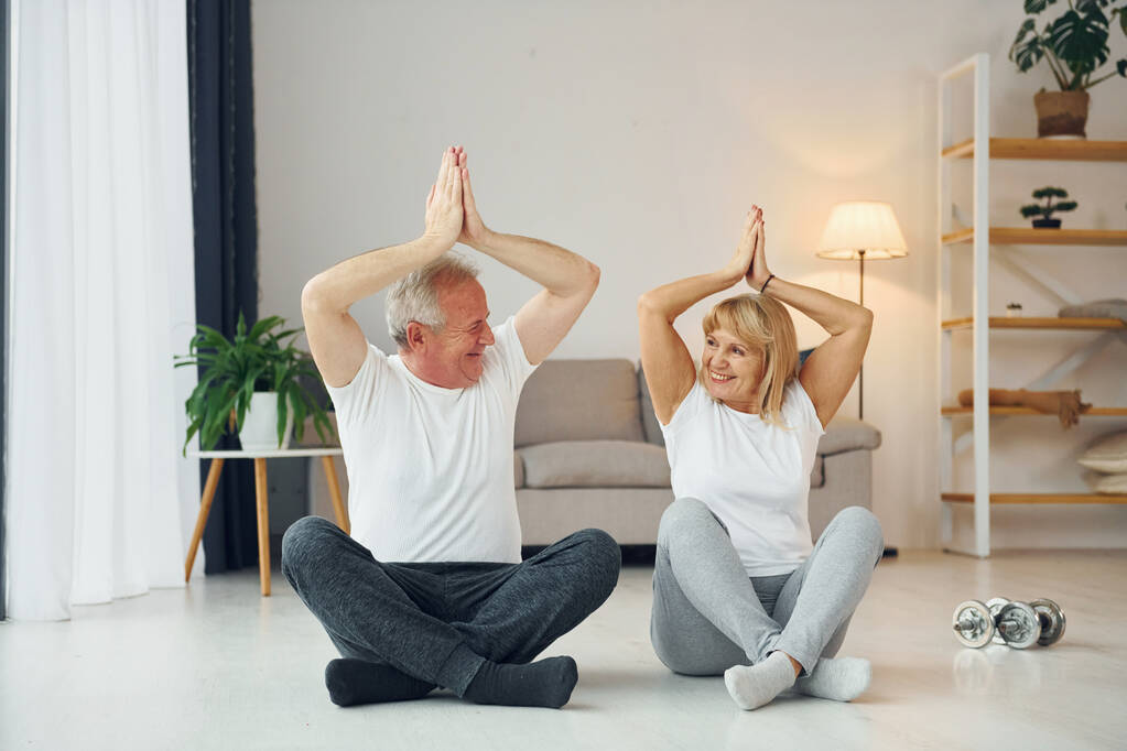 Je fais du yoga. Senior homme et femme est ensemble à la maison. - Photo, image