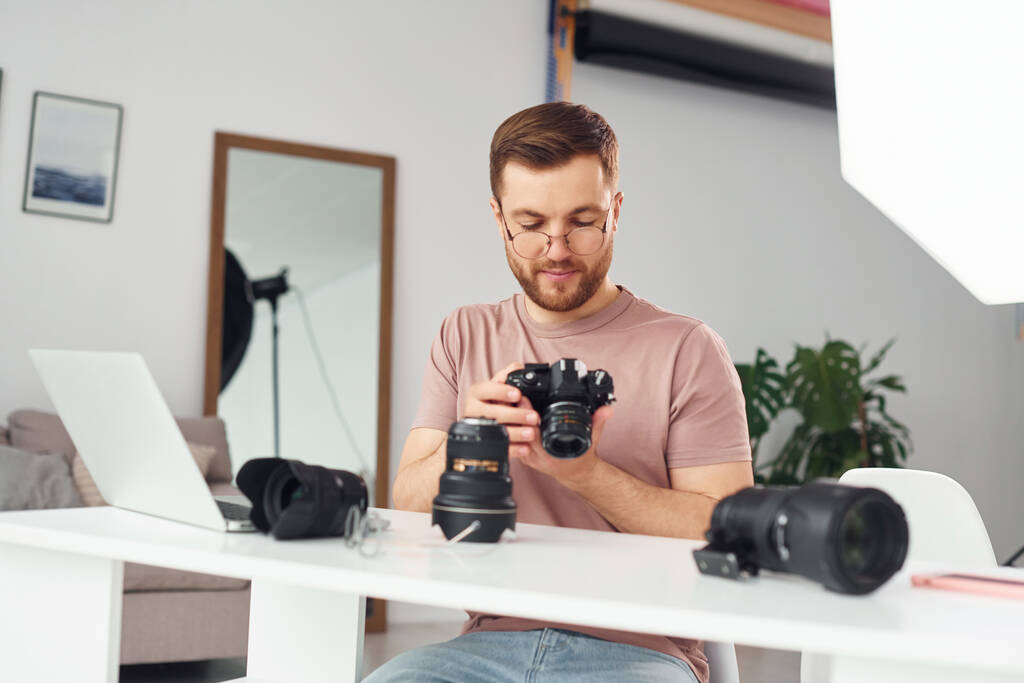Photographer in casual clothes is working indoors at daytime. - Photo, Image