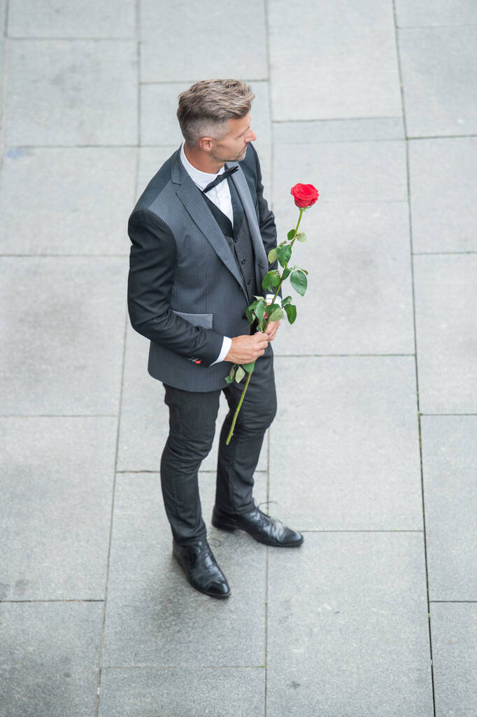 eljegyzési dátum. Karizmatikus szmokingos ember ünnepli az eljegyzést. férfi rózsa ajándék eljegyzés. - Fotó, kép