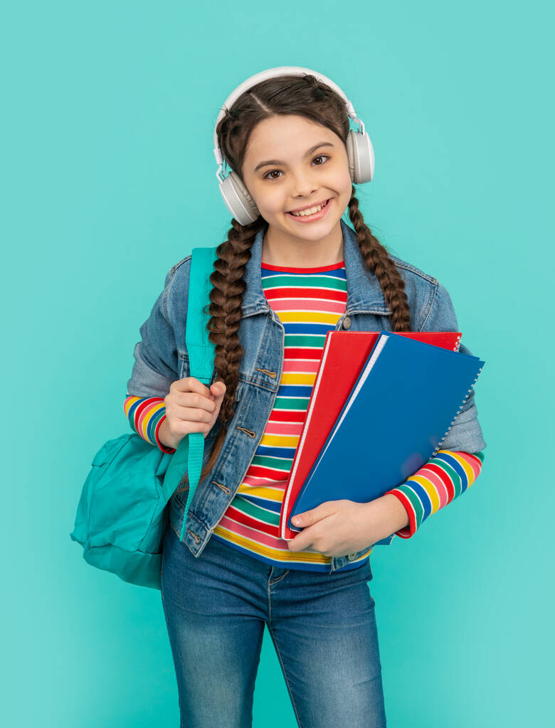Mavi sesli kurs dinleyen mutlu genç kız. Kulaklıkla sesli kitap dinleyen bir genç. Dinleme becerileri. Okul eğitimi. - Fotoğraf, Görsel