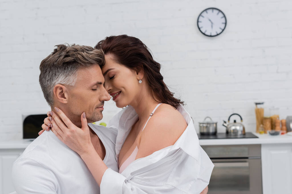 Sexy Frau im Hemd küsst und berührt Ehemann in Küche  - Foto, Bild