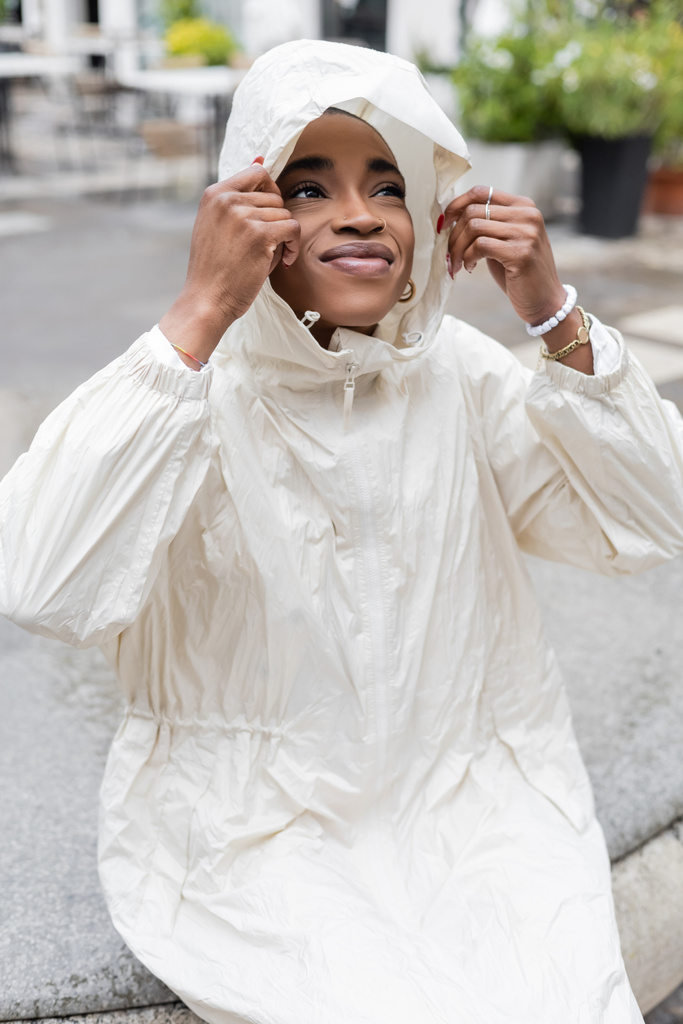 Modieuze Afro-Amerikaanse vrouw in regenjas op straat  - Foto, afbeelding