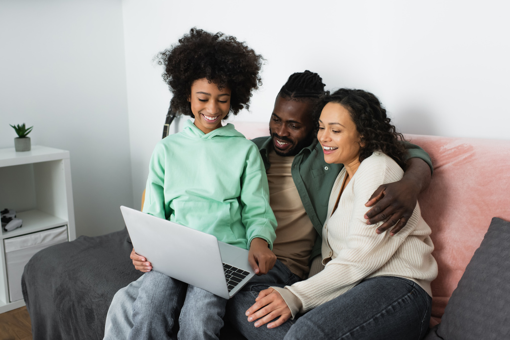 alegre família afro-americana assistindo filme de comédia no laptop na sala de estar  - Foto, Imagem