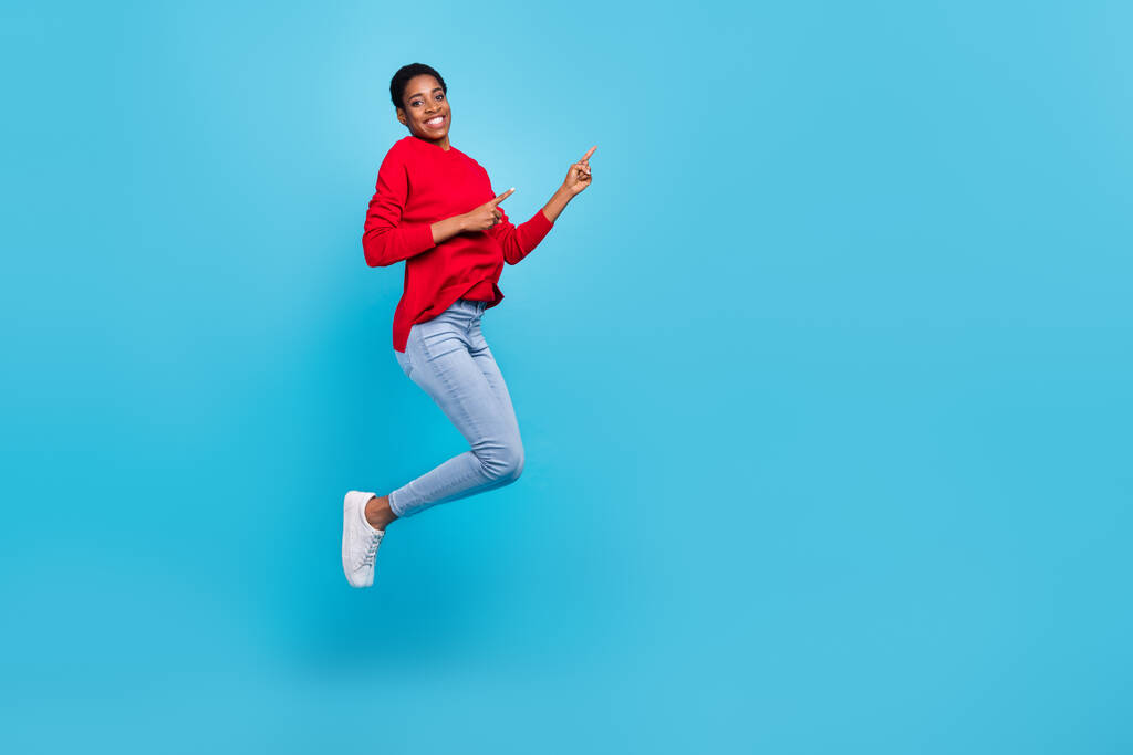 Foto de longitud completa del peinado corto milenario impresionado lady jump index promo wear jersey jeans shoes isolated on blue background. - Foto, imagen