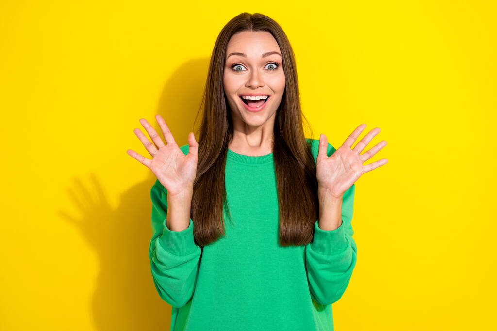 Photo of cute young lady raise hands astonished great news job promotion wear stylish green sportswear isolated on yellow color background. - Photo, Image