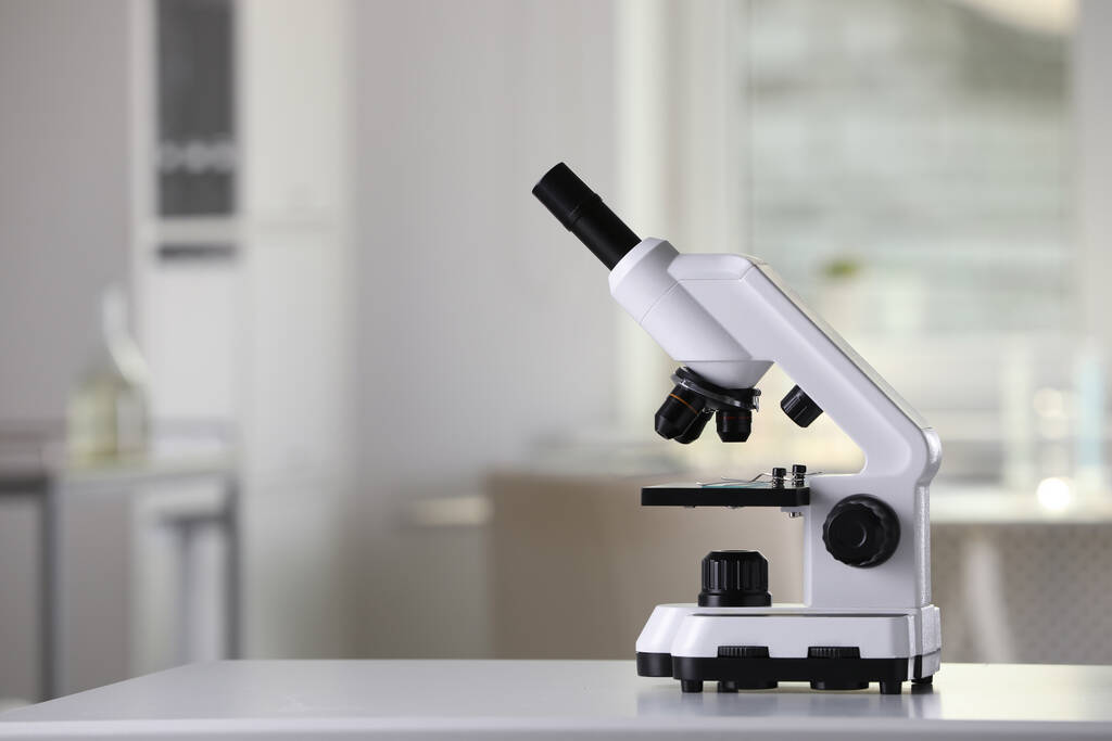 Microscópio médico moderno em mesa branca em laboratório, espaço para texto - Foto, Imagem