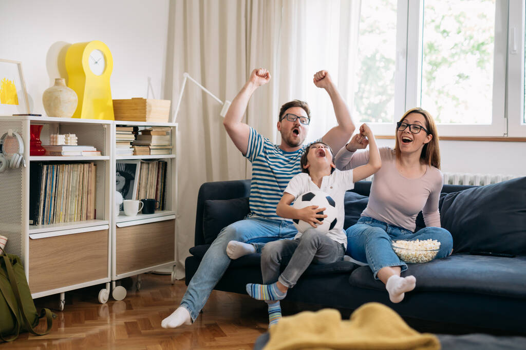 семья смотрит футбол по телевизору на дому - Фото, изображение