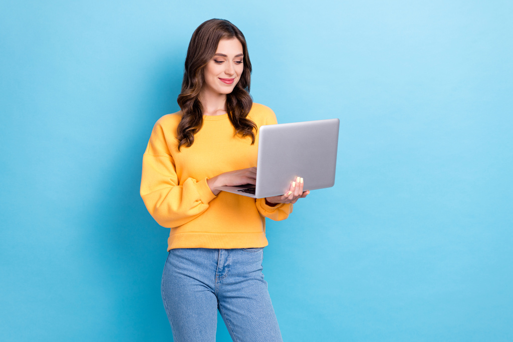 Portré fotó fiatal imádnivaló nagyon pozitív lány hold laptop profi programozó szabadúszó gépelés online elszigetelt kék színű háttér. - Fotó, kép