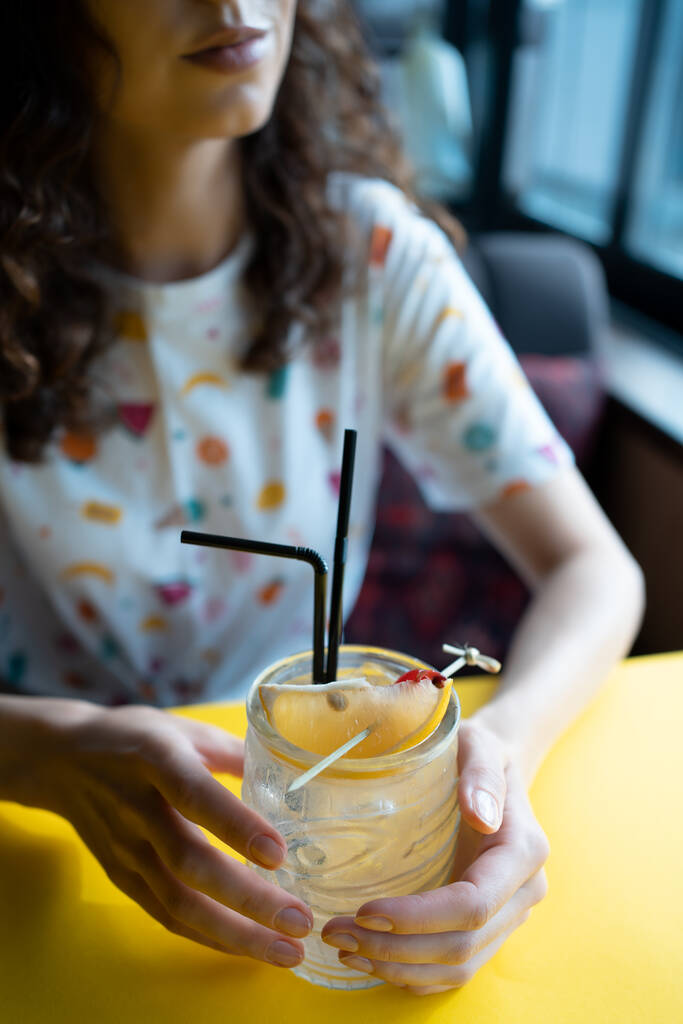 κορίτσι πίνει διαφανές κοκτέιλ σε κομψή κούπα με τεκίλα, σιρόπι και χυμό εσπεριδοειδών - Φωτογραφία, εικόνα