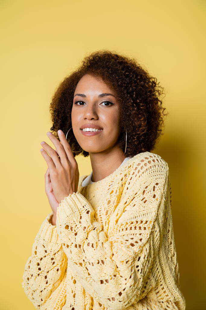 χαμογελαστή και νεαρή Αφροαμερικανή με πλεκτό πουλόβερ σε κίτρινο - Φωτογραφία, εικόνα
