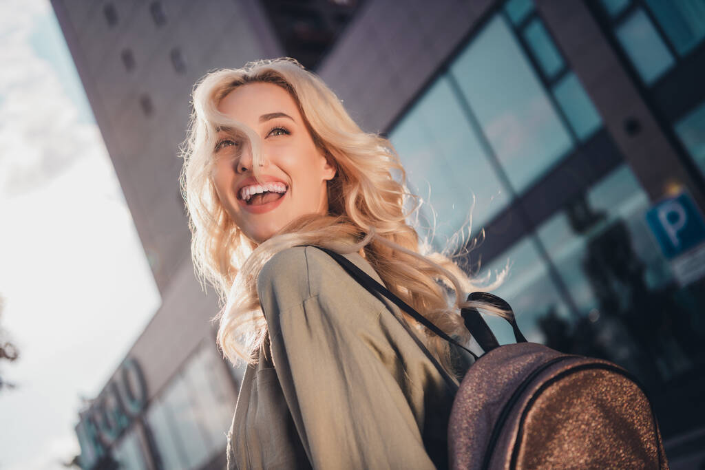 Profil Seitenansicht Porträt von attraktiven fröhlichen blonden Haaren Mädchen spazieren genießen Sonnenlicht gute Laune Reisen nach draußen. - Foto, Bild