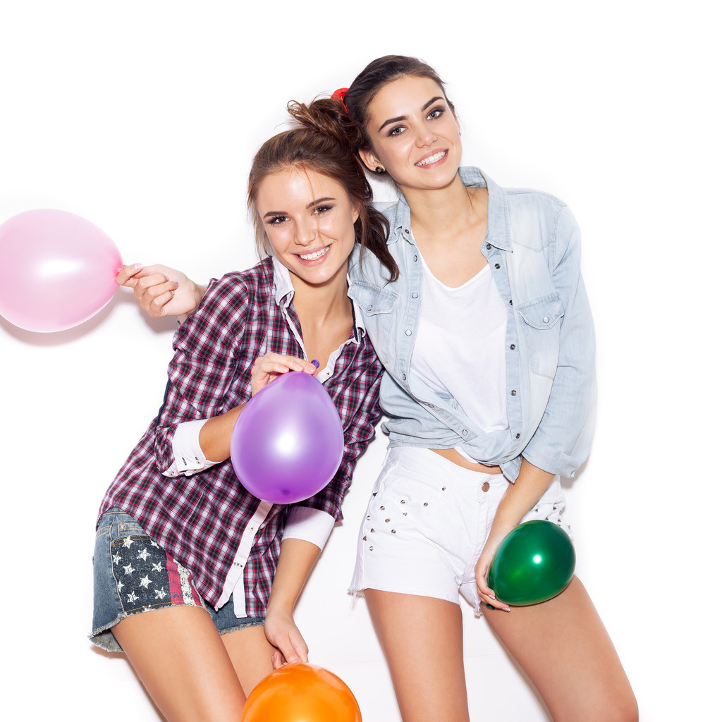 Дві подружки розважаються з кольоровими кульками
 - Фото, зображення