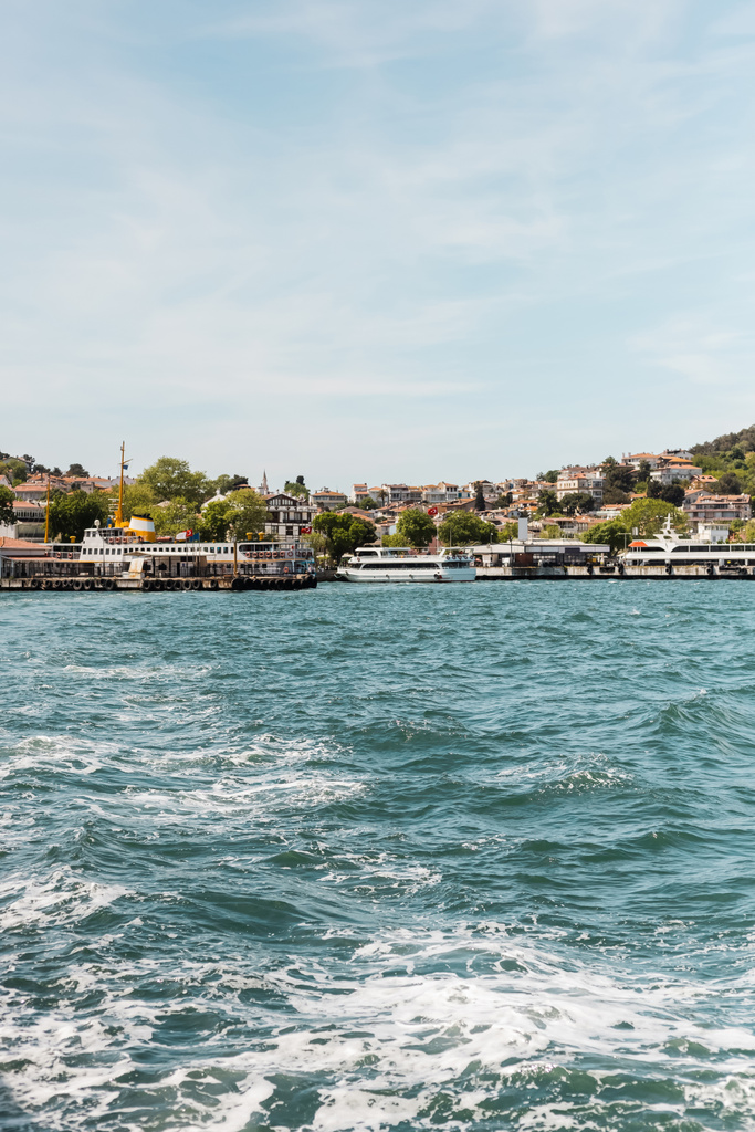 barche moderne sul Bosforo vicino al molo e case in riva al mare di Istria  - Foto, immagini