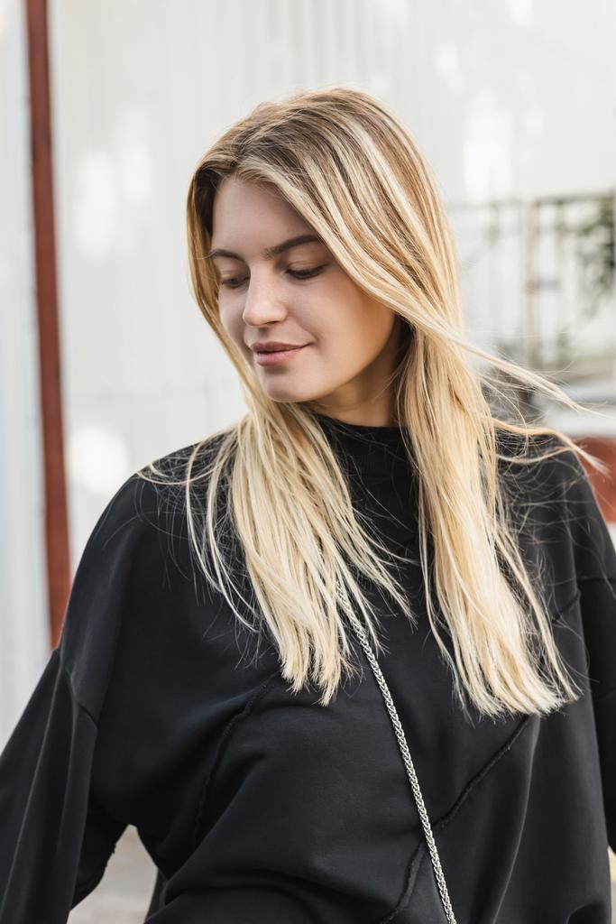 portrait de jeune femme blonde en pull noir dans la rue en dinde  - Photo, image