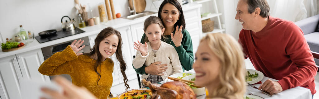 Sonriente familia multicultural tomando selfie durante Acción de Gracias en casa, pancarta  - Foto, imagen