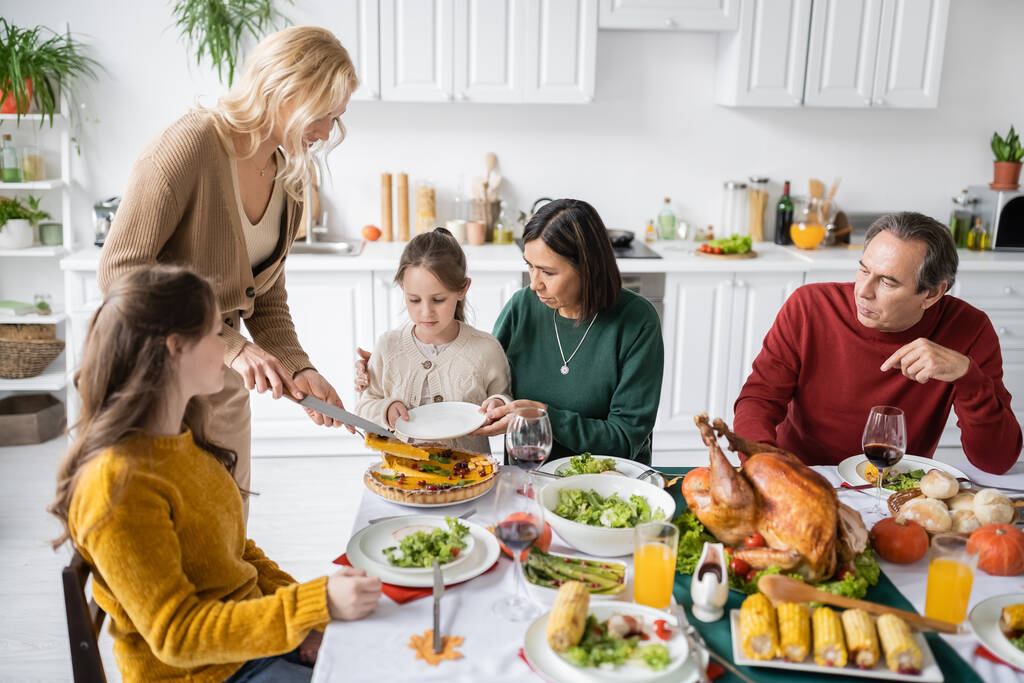 Multiethnic family celebrating thanksgiving with pie and turkey at home  - Photo, Image