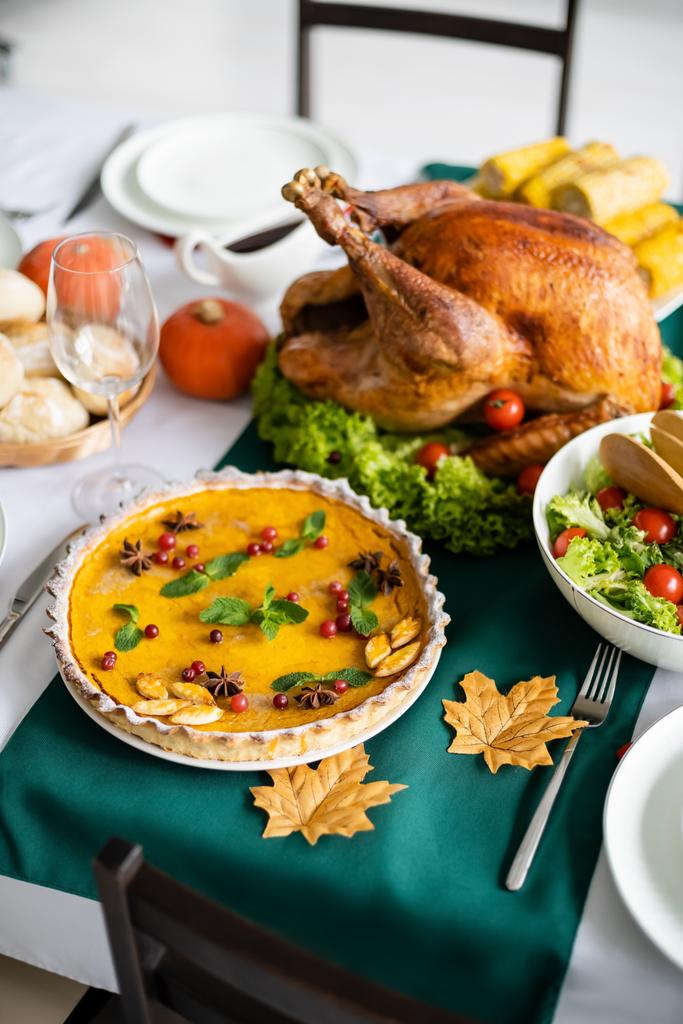traditional pumpkin pie with cranberries near roasted turkey and fresh vegetable salad - Photo, Image