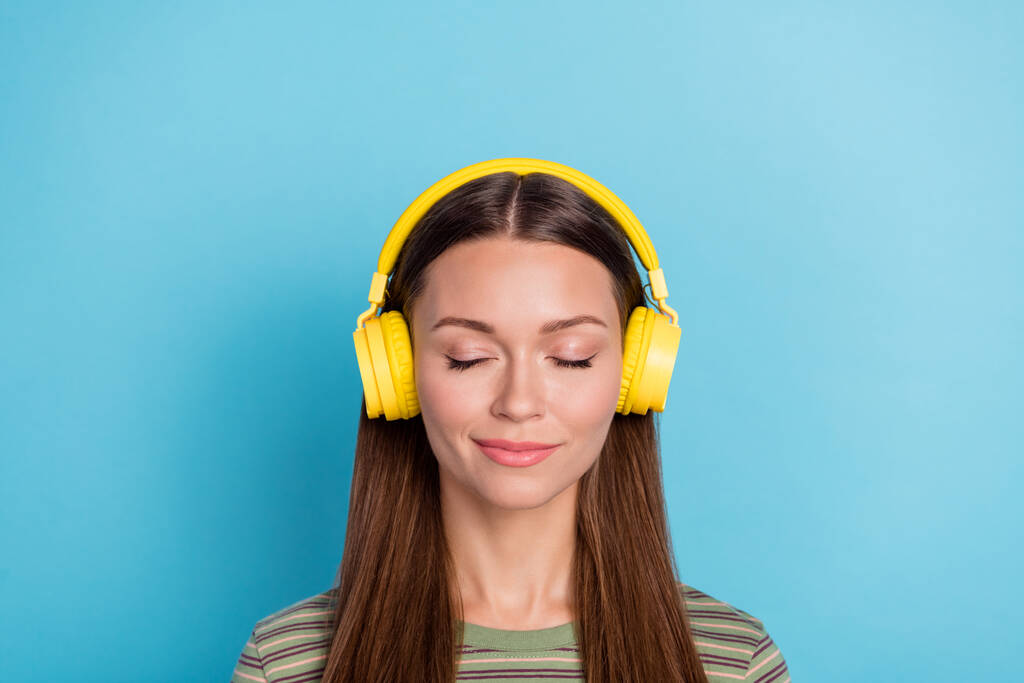 Closeup fotografie mladých rozkošný snivé hezká žena zavřené oči poslouchat rock roll hudba hlasitý nový sluchátka spací izolované na modrém pozadí. - Fotografie, Obrázek